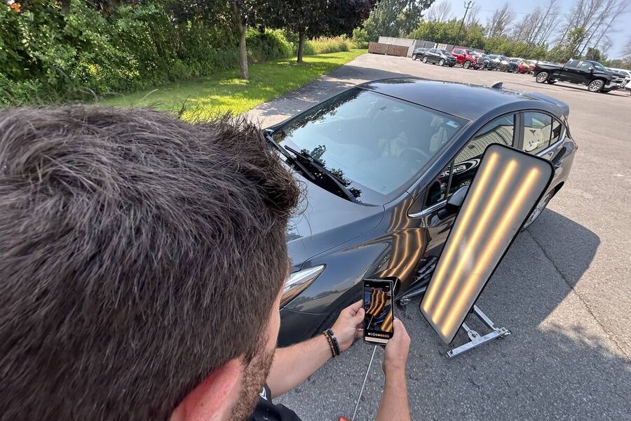 Tyler DeCarlo documenting dent repair with PDR light board